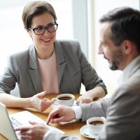 Femme et homme discutant devant un pc portable